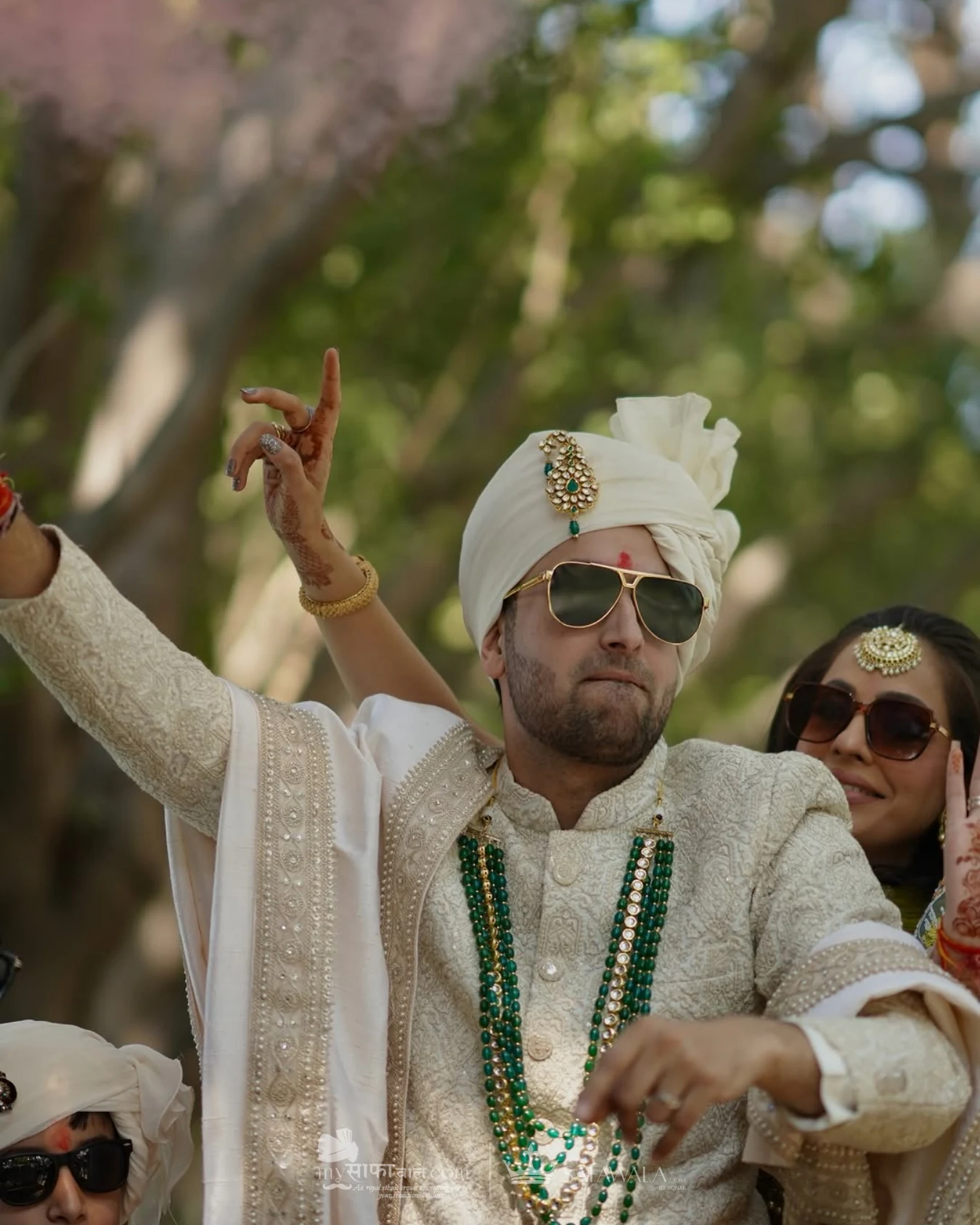 Groom in an ivory wedding safa with emerald jewellery for Almora